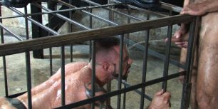 Stud In A Metal Cage Is Fucked By Horny men